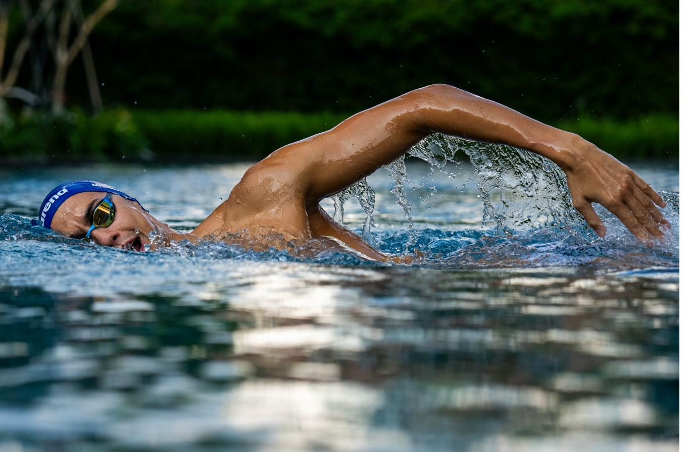 Freestyle swimmer moving through dark water